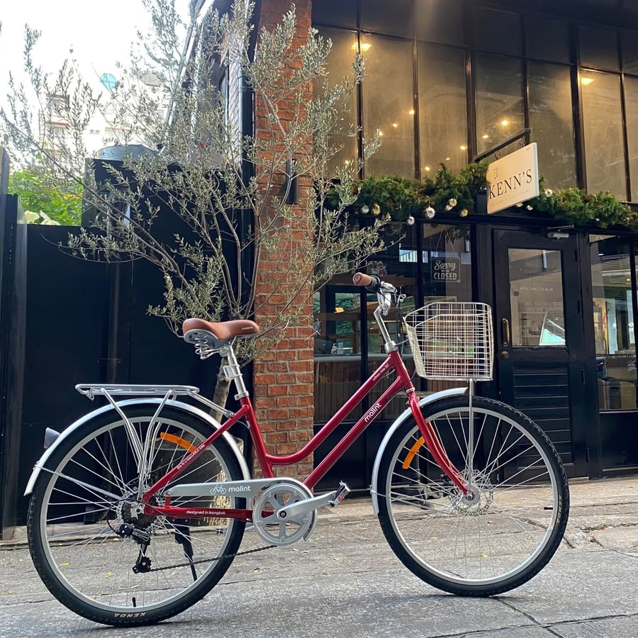 An Urban Ride in red, parked outside a shopfront