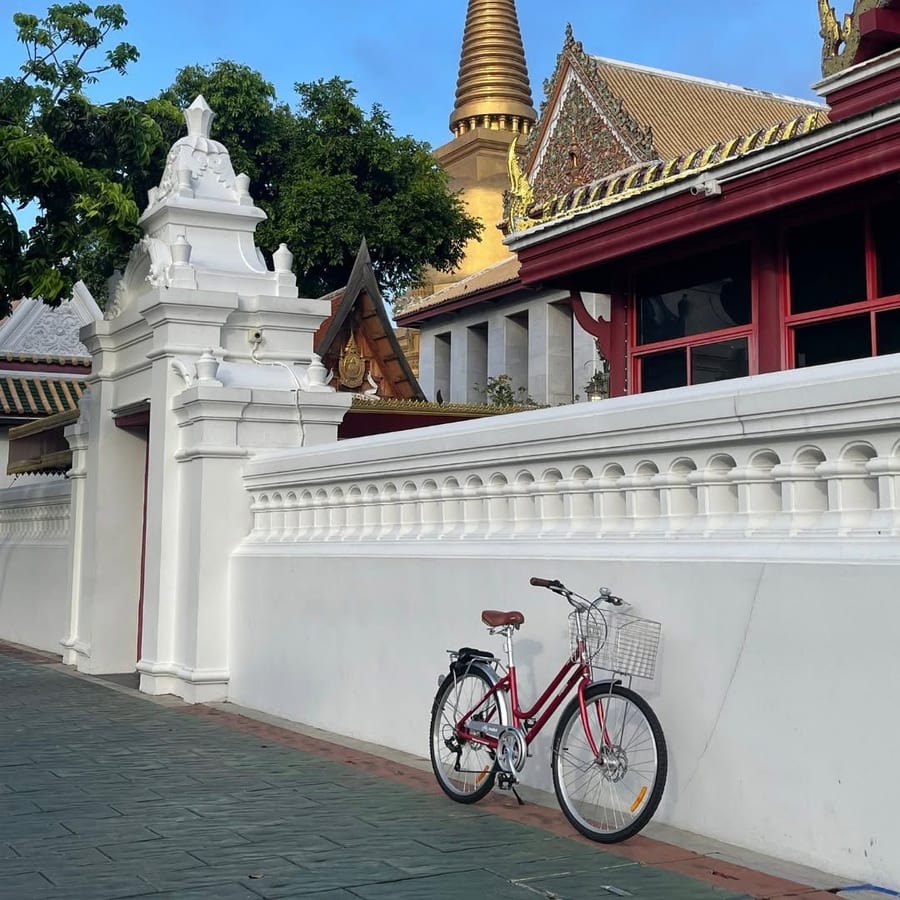 An Urban Ride in red, against a temple wall in Bangkok